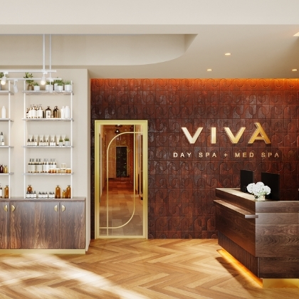 Viva Day Spa + Med Spa lobby with skincare retail shelves, arched doorway, front desk, and gold Viva logo on a wood-paneled wall