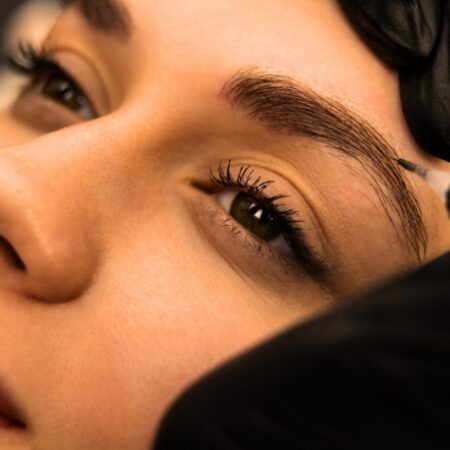 Close-up of woman getting her eyebrows tinted by a Natural Body aesthetician