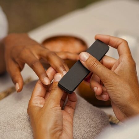 Close-up of a woman receiving a professional manicure with nail buffing at Natural Body Spa in Atlanta.