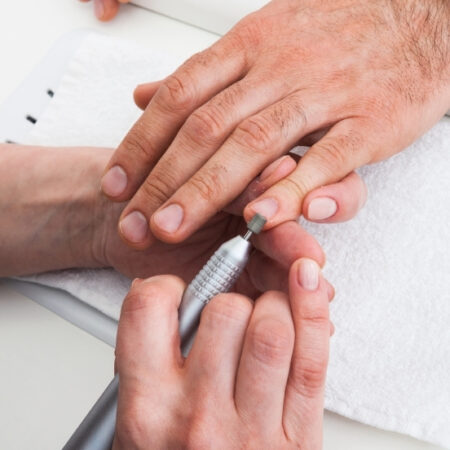 Man receiving nail grooming with an electric file during a men's manicure at Natural Body Spa in Atlanta.
