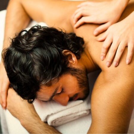 Man laying on a massage table receiving a swedish or deep tissue mens massage at Natural Body Spa + Med Spa in Atlanta, GA