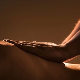 Client enjoying soothing Swedish massage strokes during a massage at Natural Body Spa.
