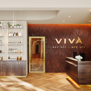 Viva Day Spa + Med Spa lobby with skincare retail shelves, arched doorway, front desk, and gold Viva logo on a wood-paneled wall